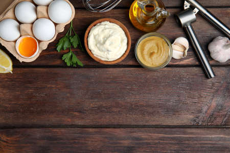 Tasty tartar sauce and ingredients on wooden table, flat lay. Space for textの写真素材