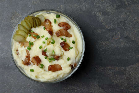 Potato puree and tasty fried cracklings on gray table, top view with space for text. Cooked pork lardの写真素材