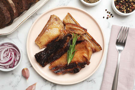 Tasty fried pork lard with rosemary on white marble table, flat layの写真素材