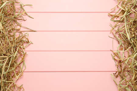 Dried hay on pink wooden background, flat lay. Space for textの写真素材