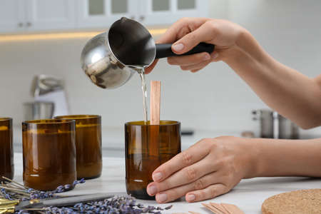 Woman making homemade candle at table in kitchen, closeupの写真素材