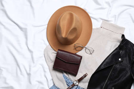 Flat lay composition with stylish hat and autumn clothes on white fabric, space for textの写真素材