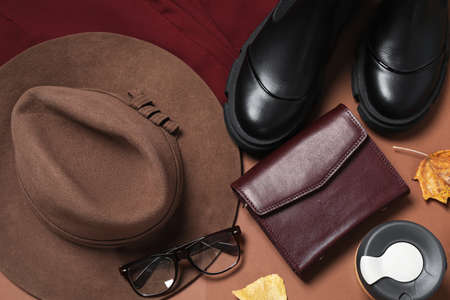 Flat lay composition with stylish hat on brown background