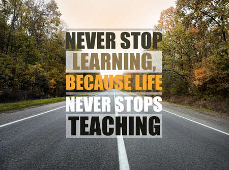 Never Stop Learning, Because Life Never Stops Teaching. Motivational quote saying that knowledge comes from everywhere every day. Text against beautiful view of empty asphalt road and autumn treesの写真素材