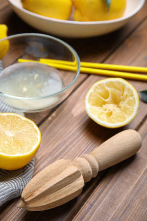 Citrus reamer and fresh lemons on wooden tableの写真素材