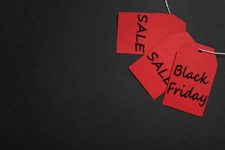 Red tags with words Black Friday and Sale on color background, flat lay. Space for textの写真素材