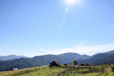 View of rural house in mountains on sunny morning. Space for textの写真素材