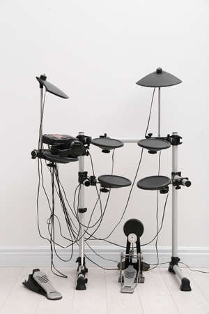 Modern electronic drum kit near white wall indoors. Musical instrumentの写真素材