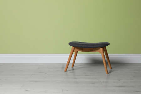Stylish stool near light green wall indoors. Space for textの写真素材