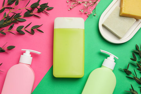 Flat lay composition with shower gel bottles and green leaves on color backgroundの写真素材