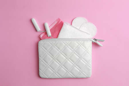 Bag with menstrual pads, tampons and pantyliners on pink background, flat layの写真素材
