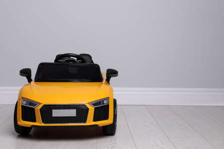 Child's electric toy car near light wall indoors. Space for textの写真素材