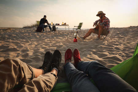 Friends resting on sandy coast, closeup. Beach campingの写真素材