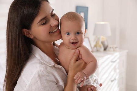 Happy young mother with her cute baby at homeの写真素材