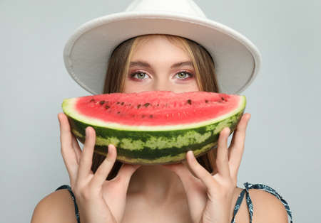 Beautiful girl with watermelon on gray backgroundの写真素材