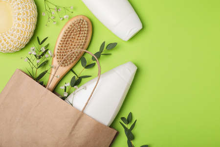 Flat lay composition with shower gel bottles and leaves on green background. Space for textの写真素材