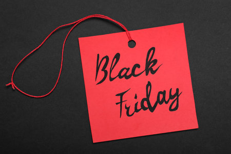 Black Friday red tag on color background, top viewの写真素材