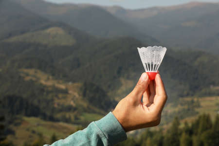 Man with badminton shuttlecock in mountains, closeup. Space for textの写真素材