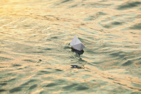 Paper boat floating on water outdoors. Space for textの写真素材
