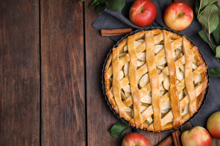 Delicious traditional apple pie on wooden table, flat lay. Space for textの写真素材