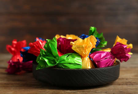 Candies in colorful wrappers on wooden tableの写真素材