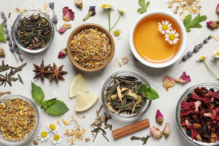 Flat lay composition with fresh brewed tea and dry leaves on light tableの写真素材