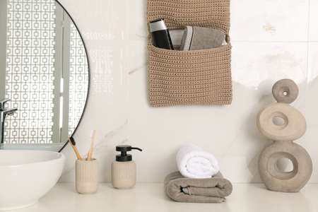 Knitted organizer hanging on wall in bathroomの写真素材