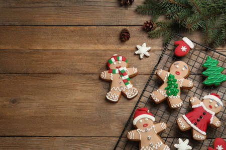 Delicious Christmas cookies and fir branches on wooden table, flat lay. Space for textの写真素材