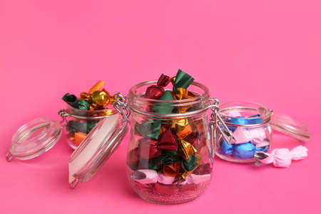 Candies in colorful wrappers on pink background