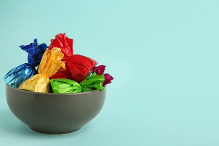 Candies in colorful wrappers on light blue background. Space for textの写真素材