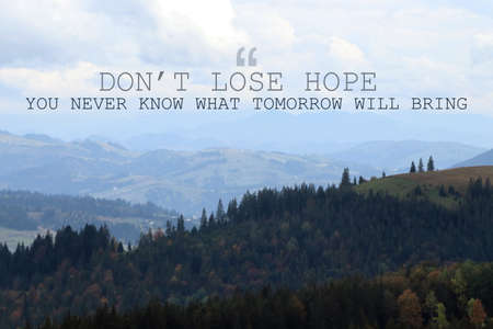 Don't Lose Hope You Never Know What Tomorrow Will Bring. Inspirational quote saying about patience, belief in yourself and next day. Text against beautiful mountain landscapeの写真素材