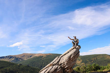Man enjoying picturesque view on cliff in mountains. Space for textの写真素材