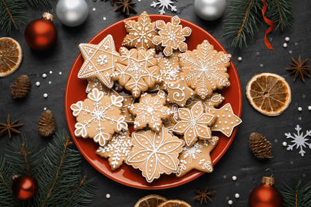Tasty Christmas cookies, fir branches and festive decor on black table, flat layの写真素材