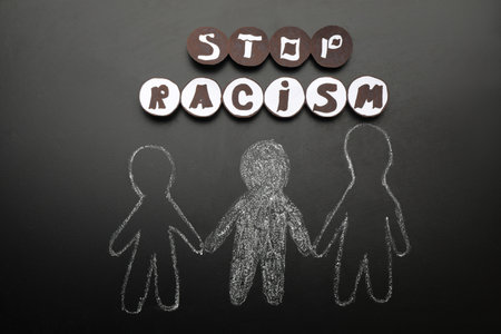 Phrase Stop Racism near white and black people drawn on blackboard, flat layの写真素材