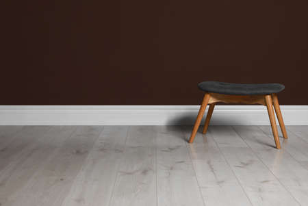 Stylish stool near brown wall indoors. Space for textの写真素材