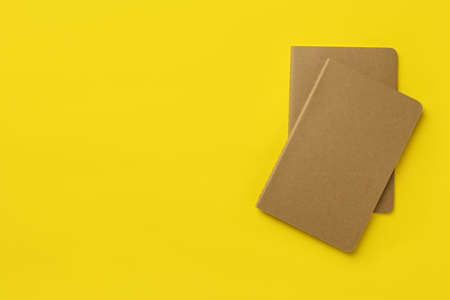 New stylish kraft planners on yellow background, top view. Space for textの写真素材