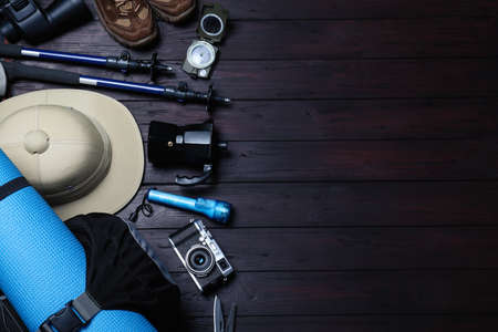 Flat lay composition with tourist backpack and other camping equipment on wooden background, space for textの写真素材