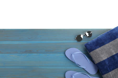 Light blue wooden surface with beach towel, flip flops and sunglasses on white background, top view. Space for textの写真素材