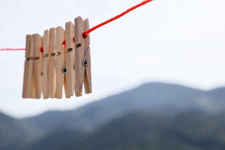 Wooden clothespins hanging on washing line outdoorsの写真素材