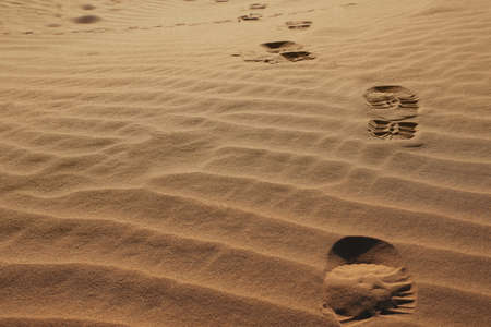 Trail of footprints on sand in desertの写真素材