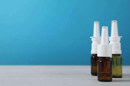 Bottles of nasal sprays on white wooden table. Space for textの写真素材