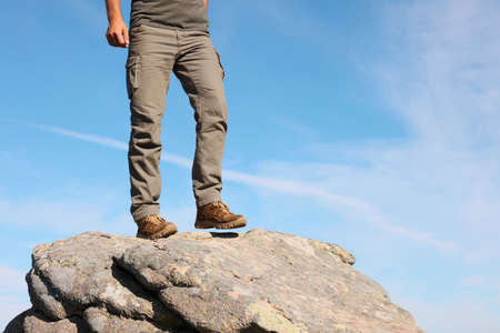 Tourist climbing on cliff, closeup of legsの写真素材