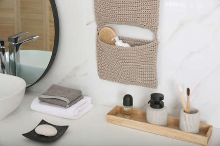 Knitted organizer hanging on wall in bathroomの写真素材