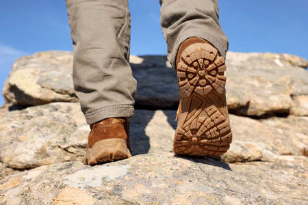 Tourist climbing on cliff, closeup of legsの写真素材