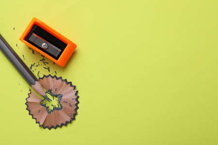 Pencil, shaving and sharpener on light green background, flat lay. Space for textの写真素材
