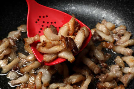 Frying cracklings in cookware, closeup. Pork lardの写真素材