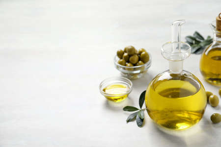 Bottle of fresh olive oil on white table, space for textの写真素材