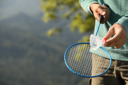 Man playing badminton outdoors on sunny day, closeup. Space for textの写真素材
