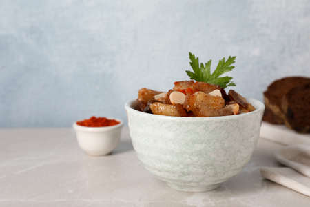 Tasty fried cracklings on light table, space for text. Cooked pork lard