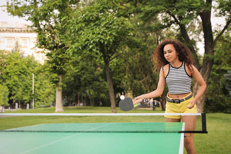 Young African-American woman playing table tennis outdoorsの写真素材